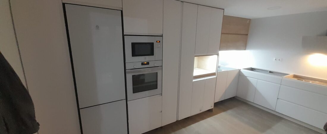Cocina blanca en L con columna de electrodomésticos